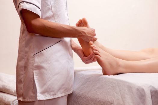 A professional masseur giving a foot massage in a spa