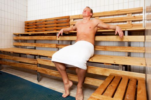 An attractive caucasian man relaxing in a sauna