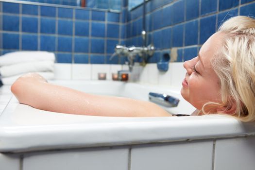 An attractive blonde woman relaxing in spa bath