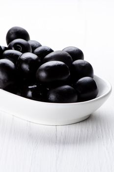 Olives in bowl  on white wooden table