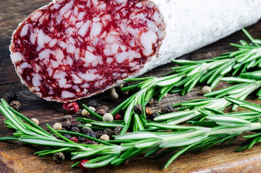 Salami and peper corns with rosemary on cutting board