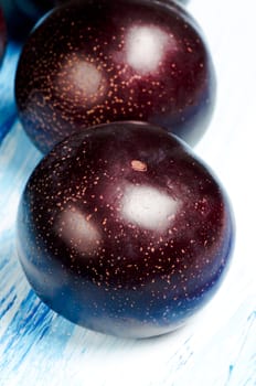 Two plums on a wooden table