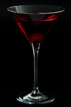 Glass with a red cocktail on a black background