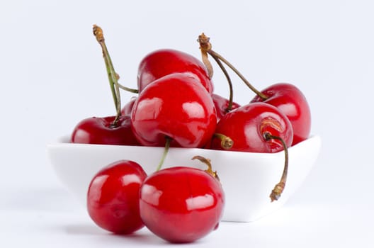 Bunch of cherries in a white bowl close up