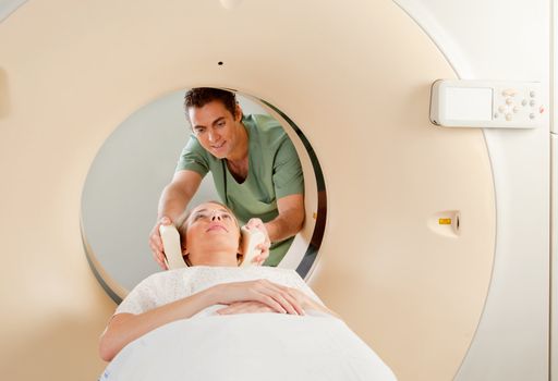 A CT Scan Technician preparing a patient for scanning