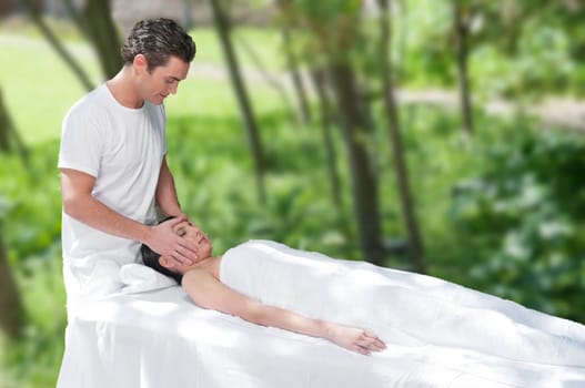 Beautiful young woman getting a face massage by a handsome man