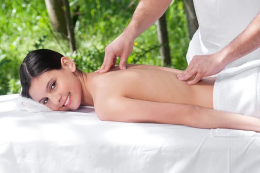 Smiling young woman getting massage from a therapist