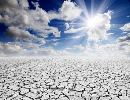 Colorful dramatic landscape with cracked soil and blue sky