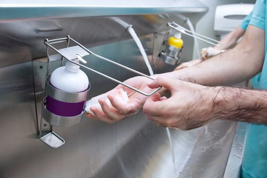 Cropped image of man washing his hand with hand sanitizer