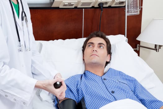 Female doctor checking patient's blood pressure in the hospital