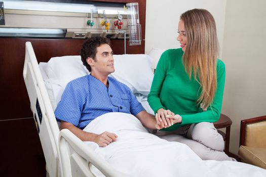 Woman comforting male patient at hospital