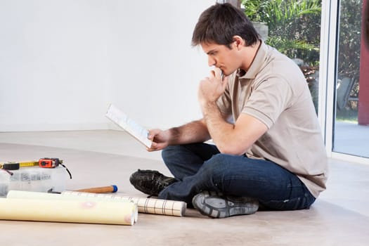 Mature man going through the color swatch while sitting on the floor