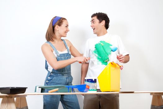 Happy Caucasian woman having fun coloring her boyfriend's shirt