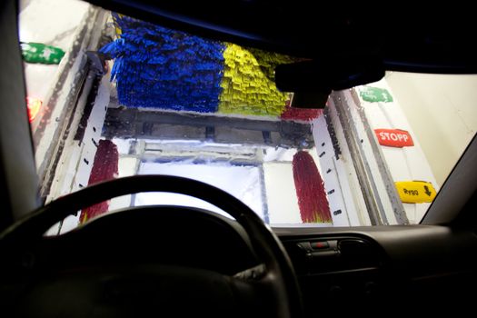 An interior of an automatic car wash, shot from inside a car