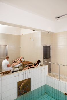 A spa interior with two women receiving a pedicure and foot massage in the background