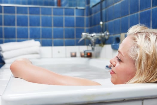 Young blond smiling women in bathtub and relaxing