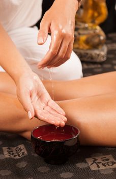 Massage therapist moistening her hands in oil