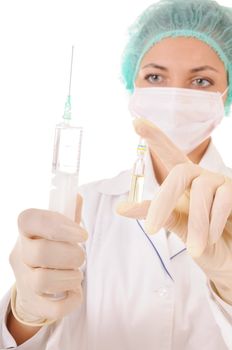 Woman in medical workwear with syringe and ampule with medicine in hands. Isolated on white background. Focus on the syringe.
