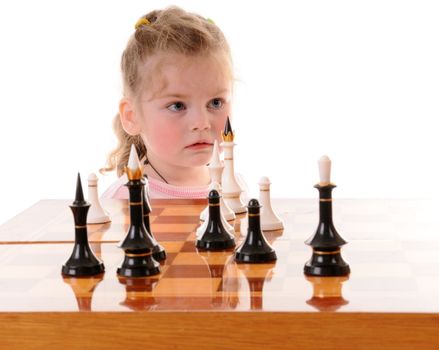 Small blonde girl playing the chess on white background