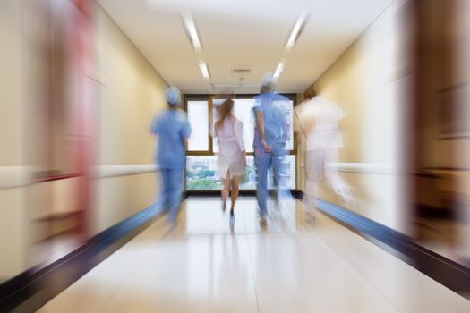 Surgeon and nurse running in passageway of hospital