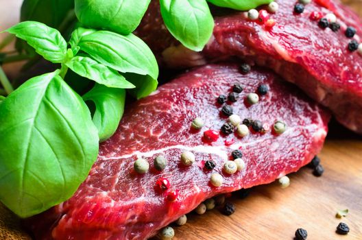Beef steak on wooden board with basil