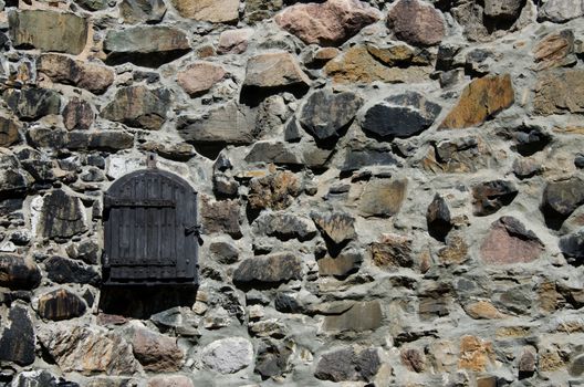 Wooden window on stone wall close up