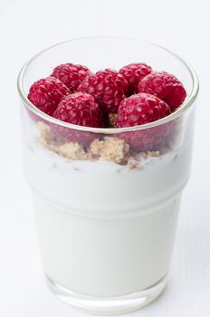 Yogurt with raspberries in  glass on white