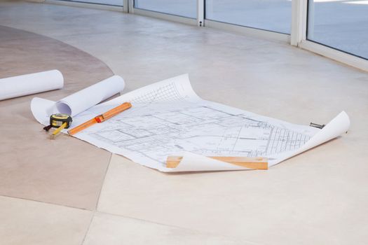 Blueprint on the floor with measuring tape and ruler
