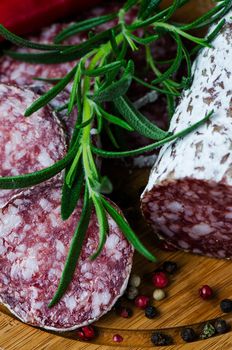 Salami pepper corns rosemary on cutting board