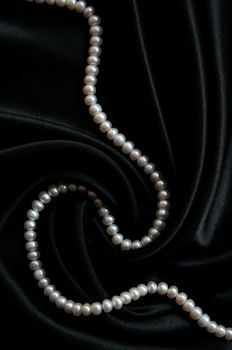 White pearls on the black velvet background 