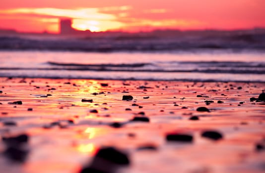 Beautiful sunset in the beach with stones on the sand