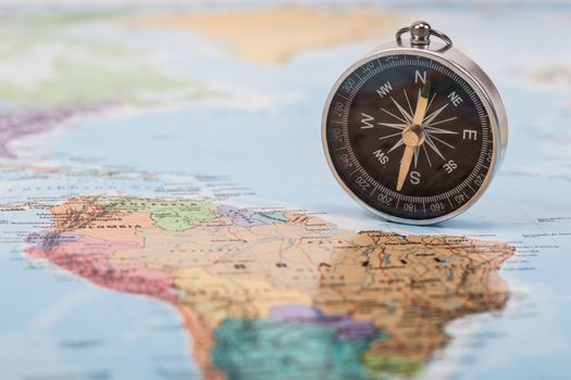 A photograph with shallow depth of field of a black compass on a map, with selective focus.