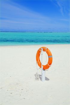 Orange lifebuoy on the beautiful white tropical beach