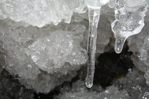 Flowing water in a brook is covered by clear ice