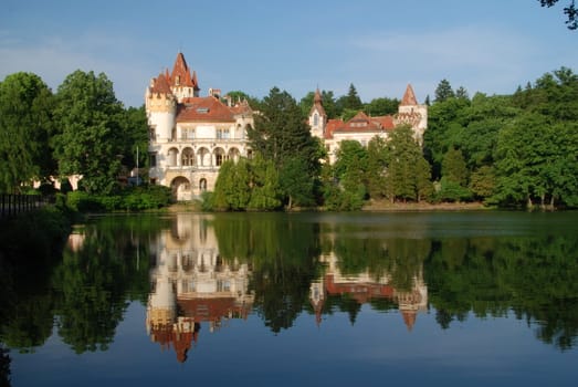 Small czech rural castle Zinkovy is reflecting in water