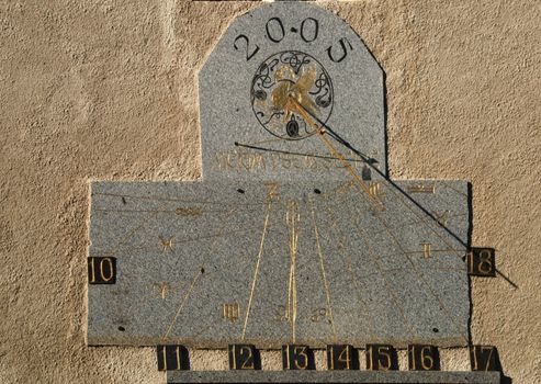 Sundial on the the wall. Measures time via shadow