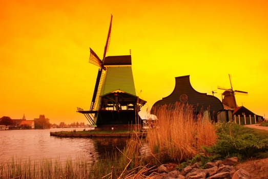 Beautiful sunset in Holland with a view at pasture with wind mills. Zaandam