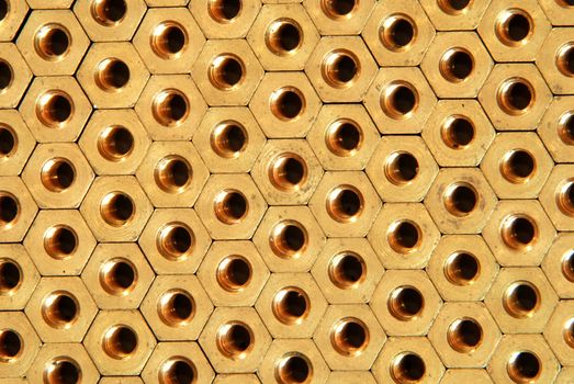 Background made of golden hexadonal screw-nuts