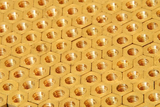 Background made of golden hexadonal screw-nuts