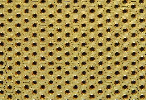 Background made of golden hexadonal screw-nuts