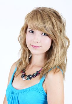 Portrait of a pretty young blond teenager girl, smiling looking at camera.