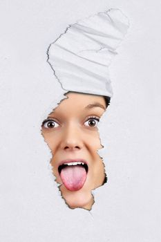 Fun ripped textured paper background with pretty young woman pulling tongue behind.