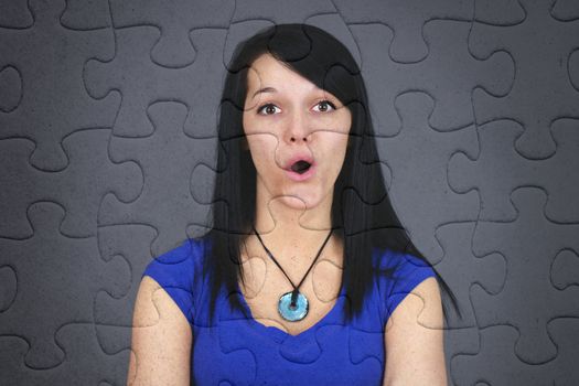 Fun concept of very surprised or puzzled young brown hair woman on jogsaw puzzle, great texture and details of the pieces.