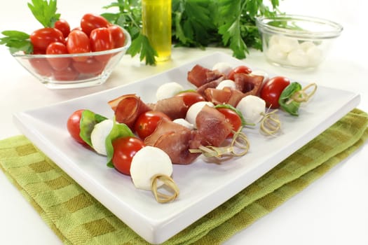 skewers with mozzarella, tomato, basil and ham