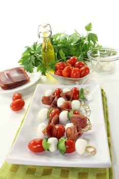 skewers with mozzarella, tomato, basil and ham