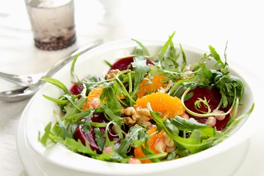 Orange,Beetroot, with walnut  rocket salad in white dish