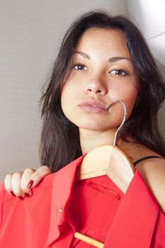 close up of girl which tries on red shirt in shop