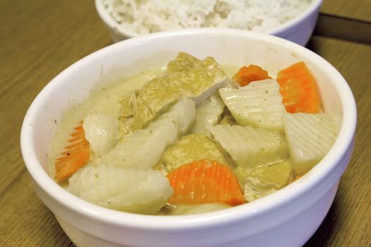 Thai Yellow Curry with Tofu Potatoes Carrots with Bowl of Rice Closeup