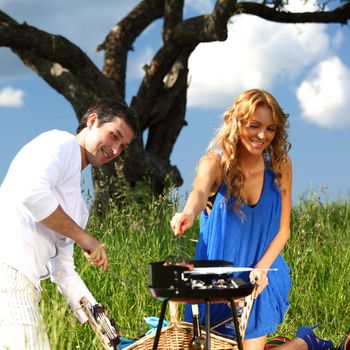 man and woman on picnic in green grass