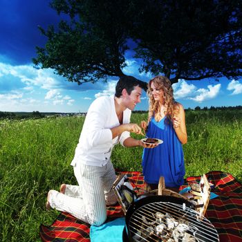 man and woman on picnic in green grass